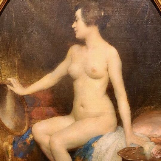 Femme nue assise sur un pan de lit se contemple dans un petit miroir doré.