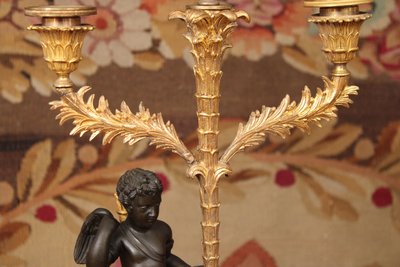 Paar Kandelaber mit drei Lichtern, verziert mit einem Amor, vergoldete und patinierte Bronze, XIX.
