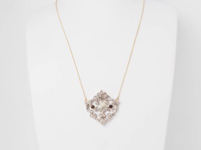 Collier volutes en or jaune et argent, grenat diamants et perle