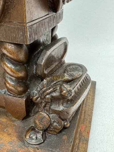 Scultura in bronzo raffigurante una donna seduta che si spoglia