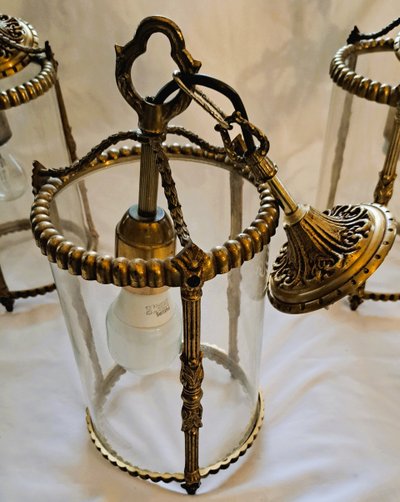 Suite de trois lanternes en bronze et verre de style louis XVI
