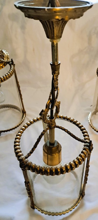 Suite de trois lanternes en bronze et verre de style louis XVI