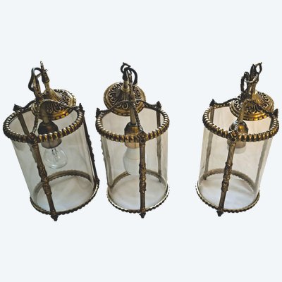 Suite de trois lanternes en bronze et verre de style louis XVI
