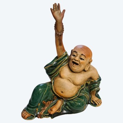 Antica statua di Buddha in terracotta con un braccio sollevato