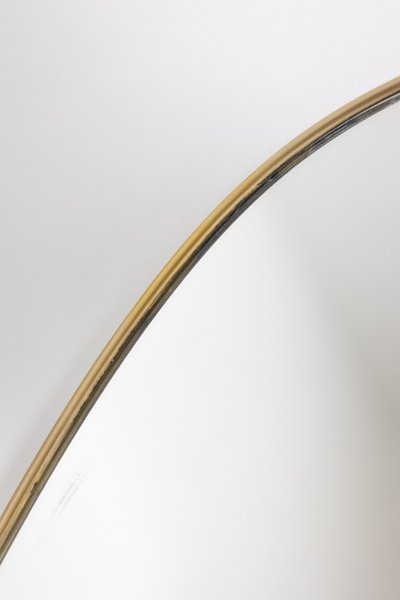 Specchio di forma ovale con asta in ottone dorato. Anni '70. Modello LS6260509U
