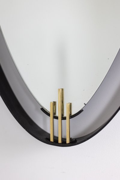 Lacquered and patinated brass mirror, ovoid shape. 1950s/60s. LS6351736M