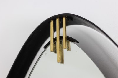 Lacquered and patinated brass mirror, ovoid shape. 1950s/60s. LS6351736M