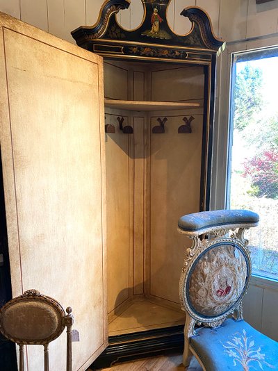 Angolo alto in legno laccato nero decorato con un vivace paesaggio e fiori