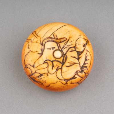 Netsuke – Grande modello in avorio tipo Manju raffigurante Tame-tomo e il lupo. Edo, Giappone, XIX secolo