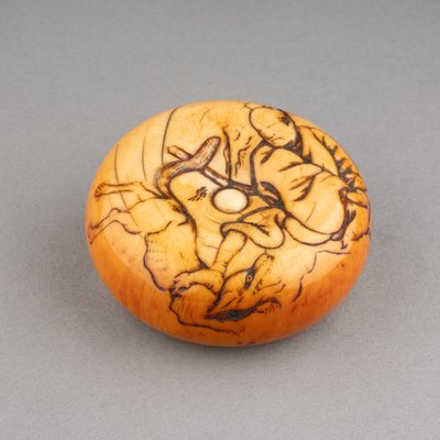 Netsuke – Grande modello in avorio tipo Manju raffigurante Tame-tomo e il lupo. Edo, Giappone, XIX secolo