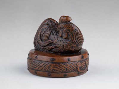Netsuke di Tametaka. Modello in legno raffigurante un gallo appollaiato su un tamburo. Edo Giappone