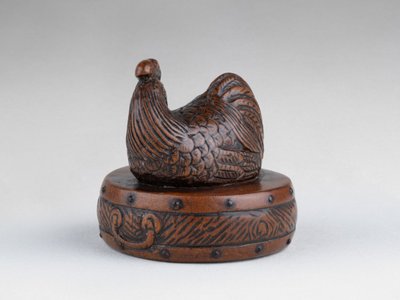 Netsuke di Tametaka. Modello in legno raffigurante un gallo appollaiato su un tamburo. Edo Giappone