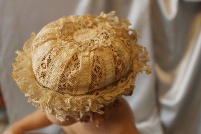 Cuffietta in pizzo batista color avorio per neonato o bambola, inizio XX secolo 