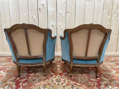 Paire de fauteuils bergères de style Louis XV en velours bleu et bois doré 