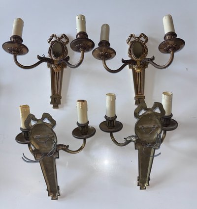 PETITOT (20th century) Series of four Art Deco wall lights with medallions, in chiseled gilt bronze
