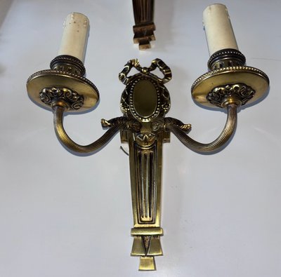 PETITOT (20th century) Series of four Art Deco wall lights with medallions, in chiseled gilt bronze