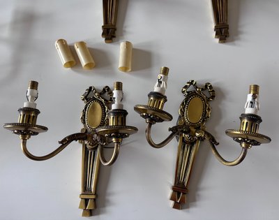 PETITOT (20th century) Series of four Art Deco wall lights with medallions, in chiseled gilt bronze