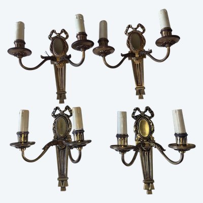 PETITOT (20th century) Series of four Art Deco wall lights with medallions, in chiseled gilt bronze
