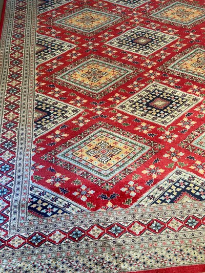 Grande tappeto pakistano firmato in lana lavorato a mano con disegno geometrico su fondo rosso