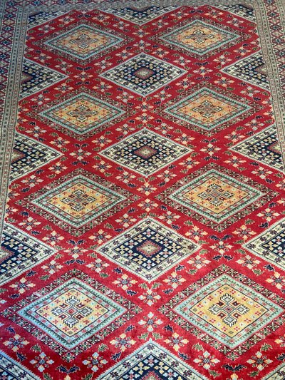 Grande tappeto pakistano firmato in lana lavorato a mano con disegno geometrico su fondo rosso