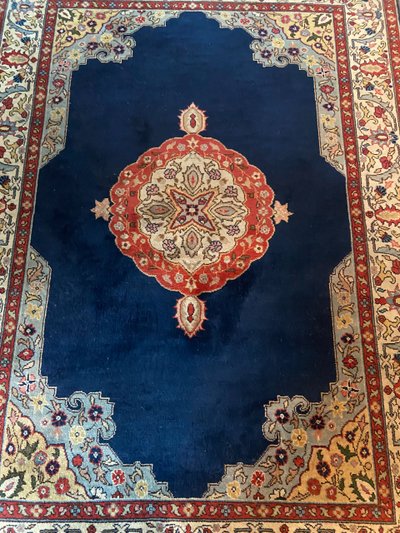 NAIN hand-knotted wool oriental rug with central medallion on midnight blue background