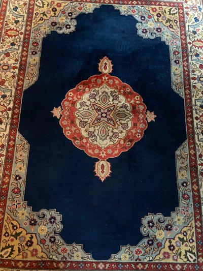 NAIN hand-knotted wool oriental rug with central medallion on midnight blue background