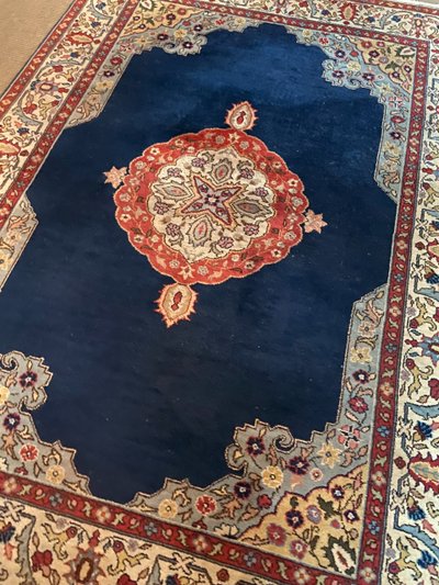 NAIN hand-knotted wool oriental rug with central medallion on midnight blue background