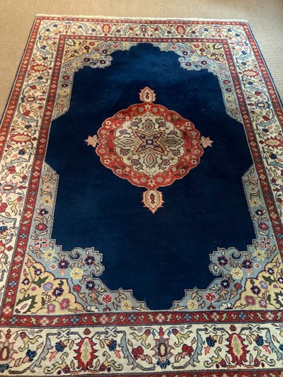 NAIN hand-knotted wool oriental rug with central medallion on midnight blue background