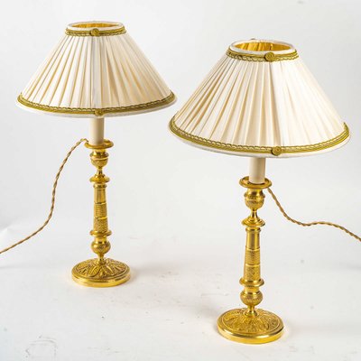 Coppia di candelabri del periodo della Restaurazione in bronzo dorato e cesellato montati come lampade, 1820-1830 ca.