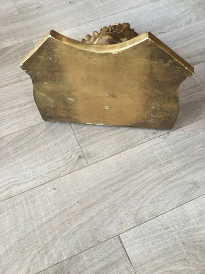 Une console murale en bois doré à tête d'angelot.