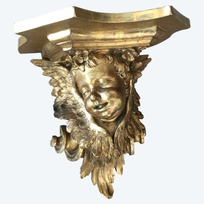 Une console murale en bois doré à tête d'angelot.
