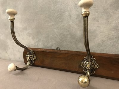 Late 19th century brass and ceramic coat rack and coat hooks on wood