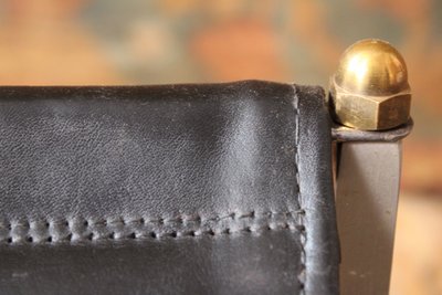 Curule stool seat in polished wrought iron with brass ornamentation, 20th century