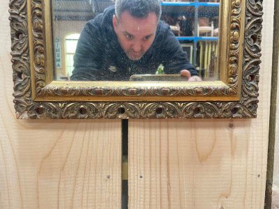 Small mirror between two in gilded wood