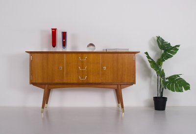 Modernistisches Sideboard mit Messing-Kompassfüßen.