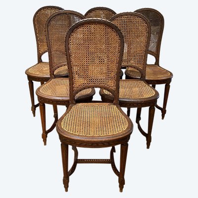 Six chaises de style Louis XVI, en chêne. Assises et dossiers cannés. Début XXe