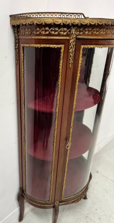 Napoleon III-style display cabinet in mahogany and veneer It opens with a curved glass door on the front.