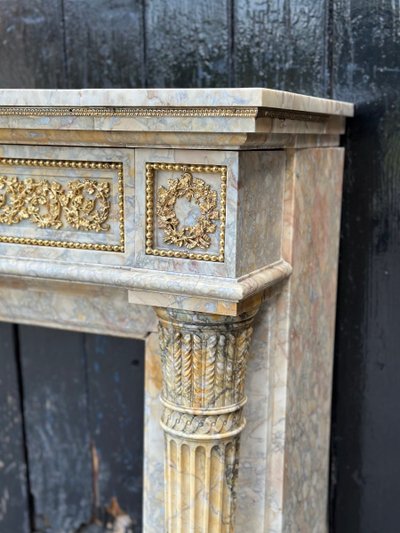 Camino in stile Luigi XVI in marmo giallo Siena e bronzi dorati