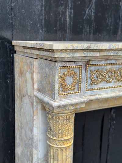 Camino in stile Luigi XVI in marmo giallo Siena e bronzi dorati