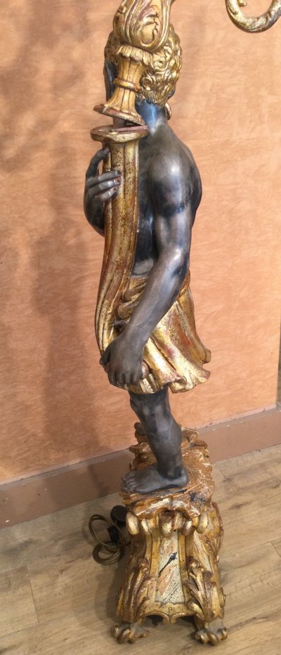 A large "Nubian" floor lamp in the Italian Baroque style, in painted and gilded wood.