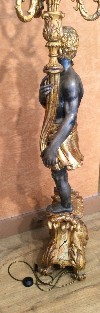 A large "Nubian" floor lamp in the Italian Baroque style, in painted and gilded wood.