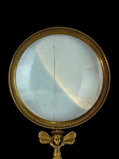 LARGE EMPIRE PERIOD MAGNIFYING GLASS IN CHASED AND GILDED BRONZE WITH WINGED FEMALE HEAD DECORATION