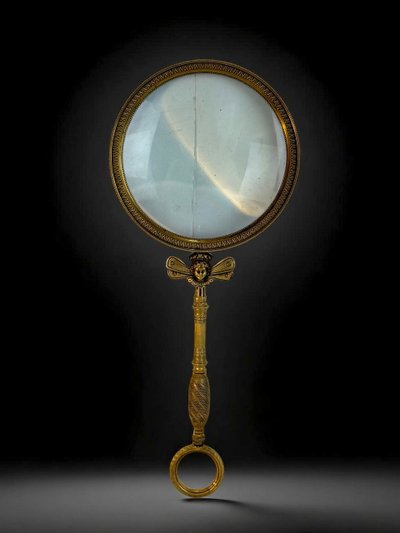 LARGE EMPIRE PERIOD MAGNIFYING GLASS IN CHASED AND GILDED BRONZE WITH WINGED FEMALE HEAD DECORATION