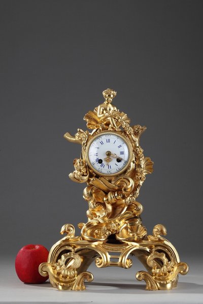 Pendule de style Rocaille en bronze doré, ornée d'un Amour dans une coquille