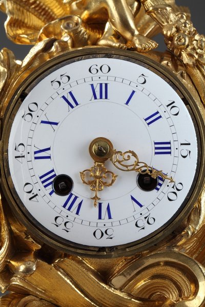 Pendule de style Rocaille en bronze doré, ornée d'un Amour dans une coquille