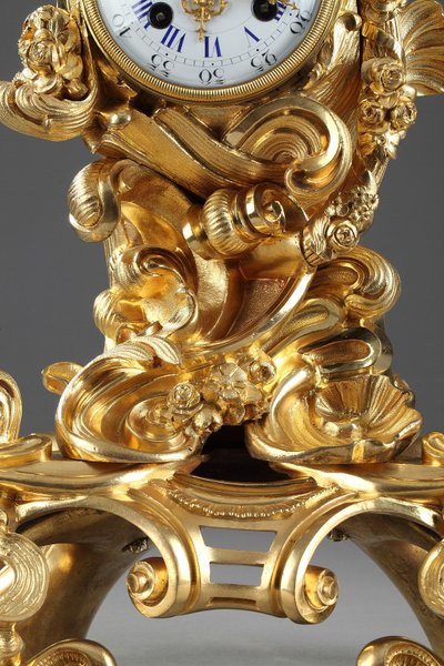 Pendule de style Rocaille en bronze doré, ornée d'un Amour dans une coquille
