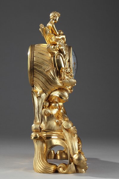 Pendule de style Rocaille en bronze doré, ornée d'un Amour dans une coquille