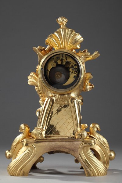 Pendule de style Rocaille en bronze doré, ornée d'un Amour dans une coquille