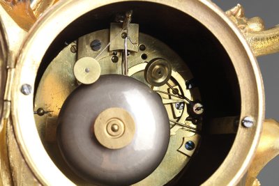 Pendule de style Rocaille en bronze doré, ornée d'un Amour dans une coquille