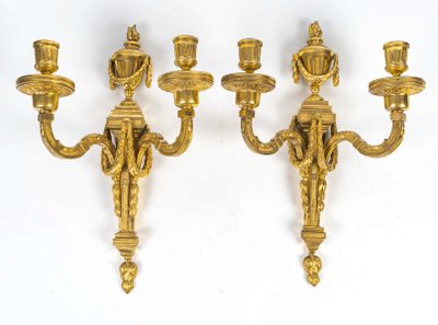Coppia di appliques in bronzo cesellato e dorato in stile Luigi XVI con due bracci di luce 1820 ca.